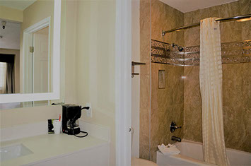 Guest Bathroom with tub and shower combination. Vanity with mirror and coffee maker.
