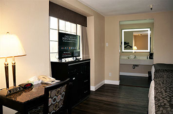 This 2 Double bed room includes a writing desk with chair, lamp, alarm clock, phone, chest of drawers ith a large flat screen television. 